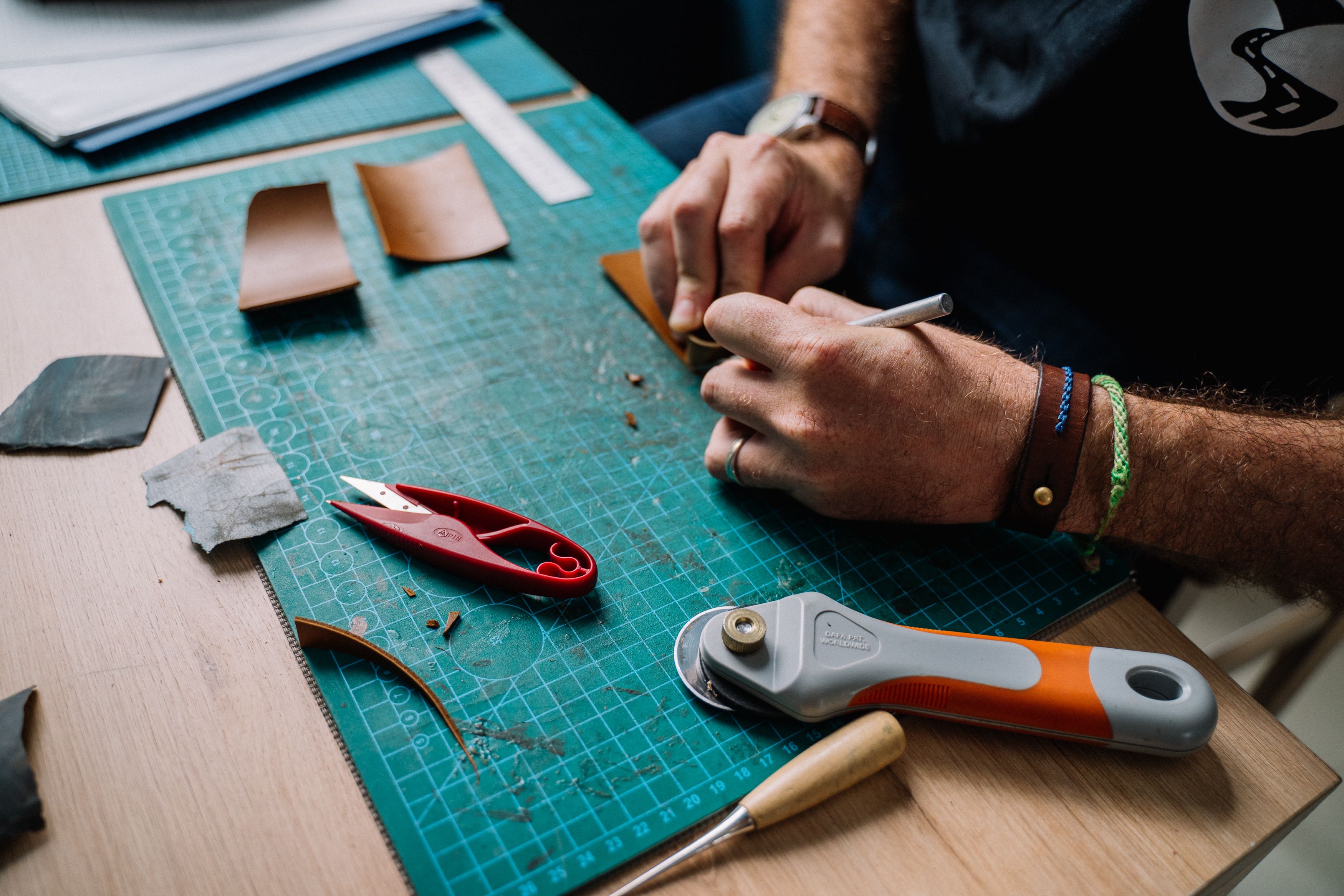 Hands shaping leather at the workbench